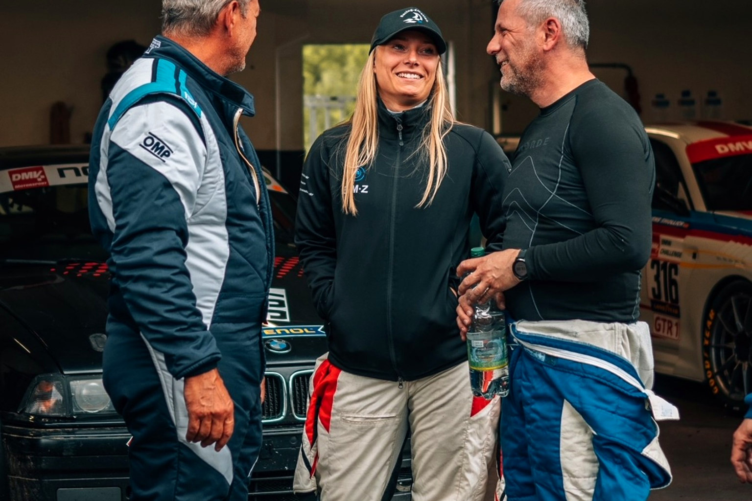 Sally Erdmann im Gespräch mit zwei Motorsportbeteiligten